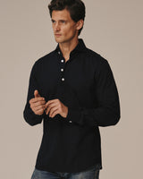 Male model wearing the navy Piqué Polo Shirt untucked.