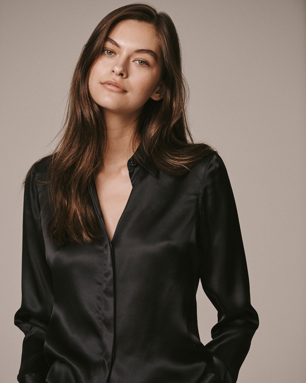 Close-up of a female model wearing the black Victoria Silk Shirt with a point collar and concealed buttoned placket.