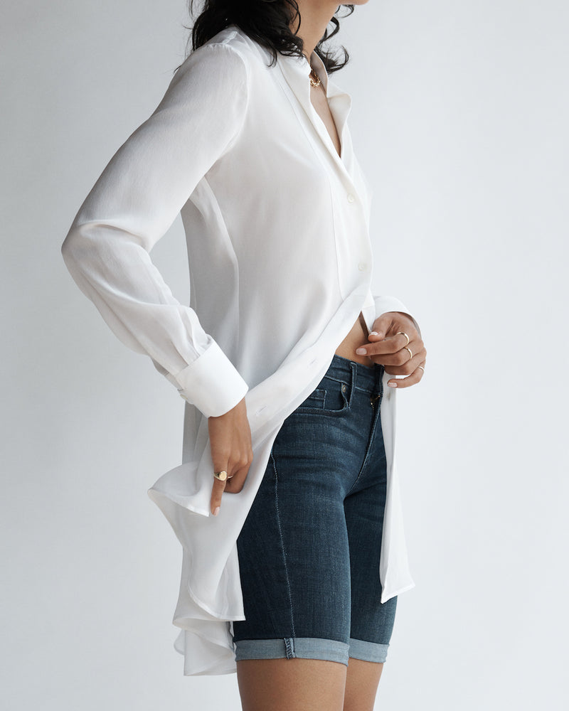 Side view of a female model wearing the Diana Silk Crepe de Chine Shirt and jean shorts.
