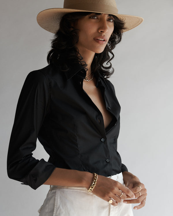 Female model wearing the Lisette Stretch Poplin Shirt, white pants and hat.