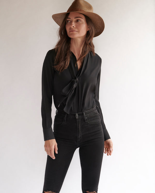 Female model wearing the black Lilly Silk Bow Blouse.