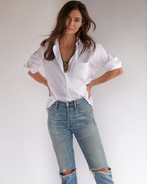 Female model in the white Fletcher Twill Shirt, squash blossom necklace, and ripped jeans. 