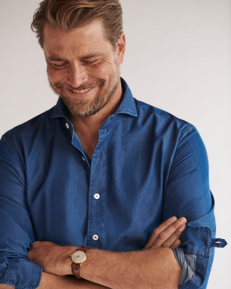 Close-up of a male model wearing the Pearson Denim Shirt with a cutaway collar.