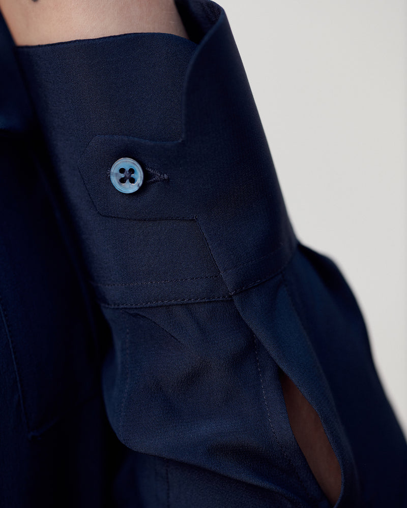 Close-up of the signature tab cuff on the navy Silk Crepe de Chine Military Shirt.