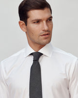 Male model wearing the Jonathan Mezibov Carmichael Solid Poplin Shirt and Woven Grenadine Silk Tie.